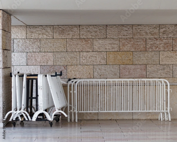 Fototapeta Crowd control barriers stored next to a wall.