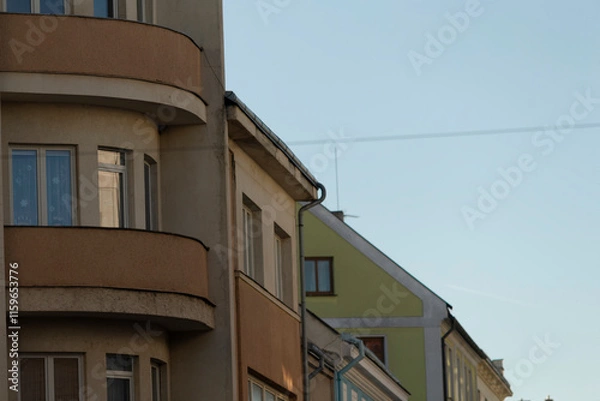 Fototapeta An urban scene showcasing distinct architectural elements of various buildings set against a clear, blue sky backdrop