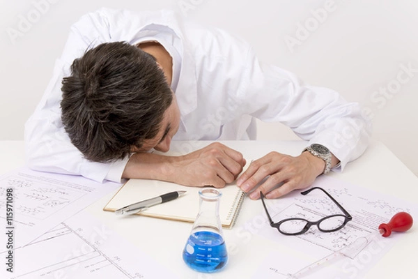 Fototapeta 開発に疲れテーブルに突っ伏す男性研究者