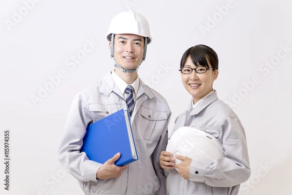 Fototapeta ファイルとヘルメットを持ちカメラ目線の男女作業員