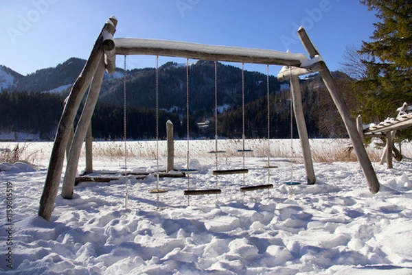 Fototapeta Spielplatz im Winter mit Klettergerüst und Schaukeln