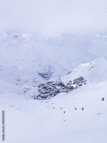 Obraz Val Thorens covered in snow, surrounded by the French Alps under a cloudy sky. A peaceful winter scene.