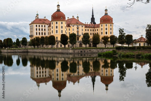 Fototapeta Landscape with a castle and its reflection on the surface of a body of water in Moritzburg, Germany.