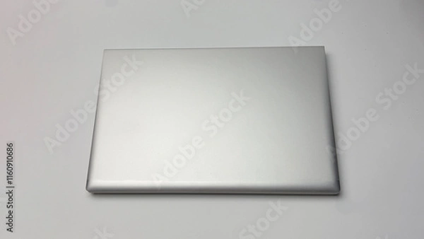 Fototapeta A white laptop is on a white background. The laptop is the main focus of the image. The background is plain and simple, with no other objects or distractions. Concept of focus and productivity