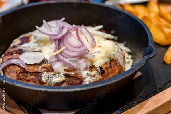 Fototapeta Onion Burger. Meat burger of ground meat fried in oil on a frying pan with three types of onions, close up