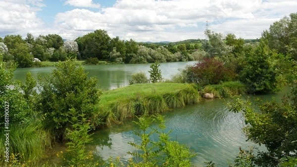 Fototapeta Scenic View of a Serene Lake with Lush Green Surroundings