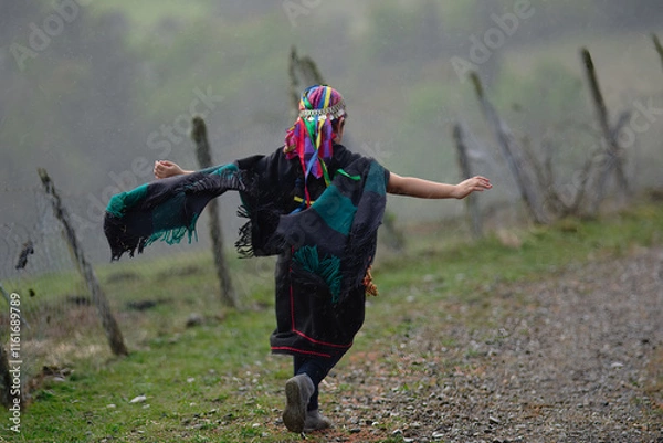 Fototapeta Joven etnia Mapuche, corriendo libremente en un campo con los brazos abiertos. 