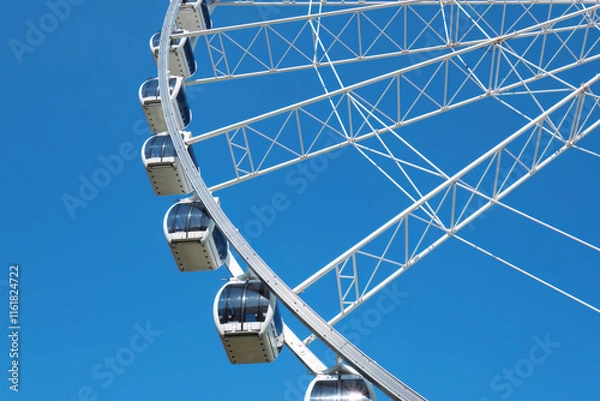 Obraz Gondolas and spokes of a Ferris wheel against a clear blue sky