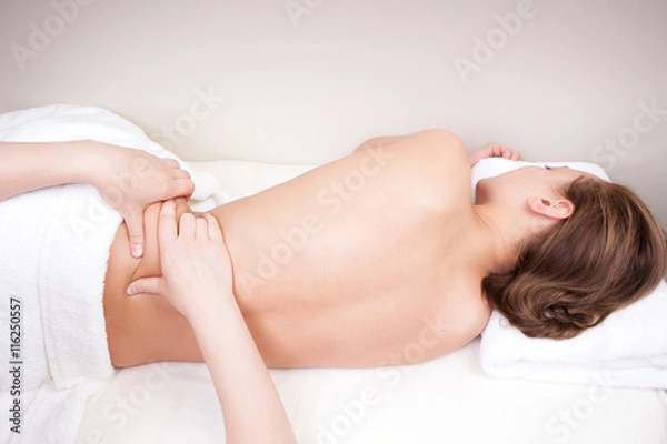 Fototapeta Deep tissue massage on a woman's hip gluteus muscles