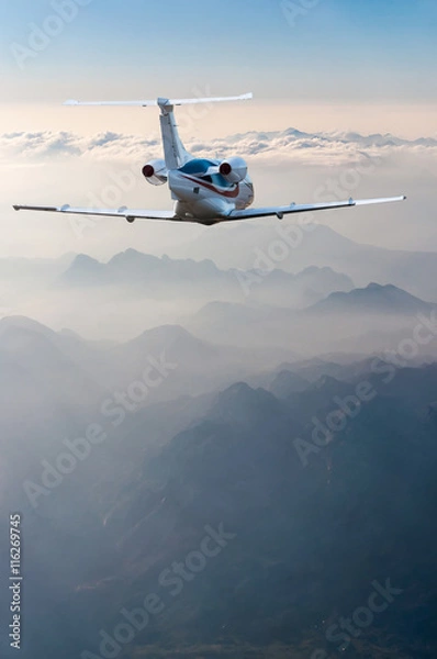Obraz perspective view of jet airliner in flight with mountains background
