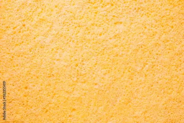 Fototapeta Close-up of a soft, textured yellow sponge cake surface,