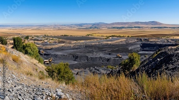 Fototapeta Open-pit coal mining site with machinery and expansive landscape.