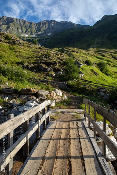 Obraz Scenic mountain landscape in Tyrol, Austria. Rolling green hills, rugged alpine peaks, and a clear blue sky capture the peaceful beauty of the summer Alps.