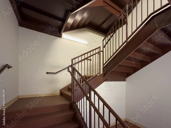 Fototapeta Close-up photo of a brown metal exit stairway, stair case, between floors of a commercial building.	