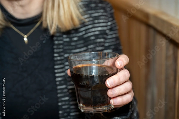 Obraz verre de soda dans la main d'une femme dans un café