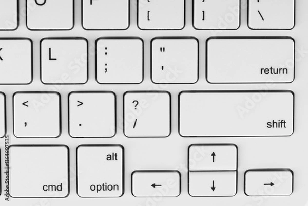 Obraz Close-up view of a white keyboard with black lettering on the keys. It could be relevant for topics related to technology, typing or computer hardware.