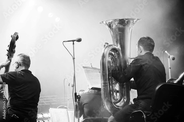 Fototapeta Symphony orchestra on the stage, tuba and double bass players, behind the scenes shoot in black and white