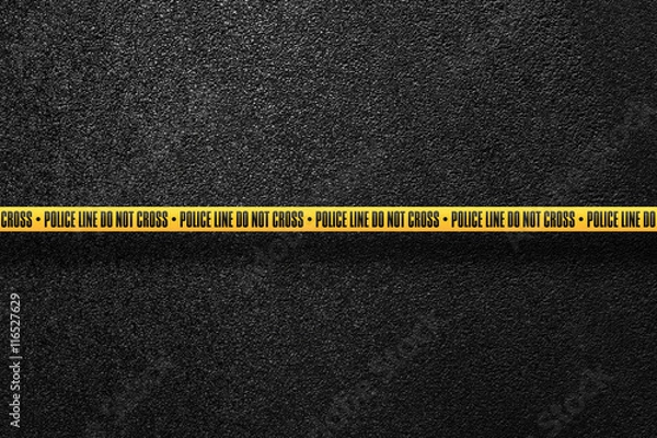 Fototapeta Yellow police line in the background smooth asphalt road. Do not cross. The texture of the tarmac, top view.