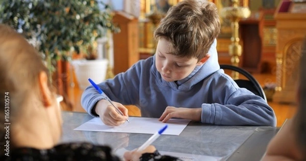 Obraz Focused student writing intently during lesson, teacher guiding study inside church interior, highlighting educational commitment within religious learning space. Concept teaching children to write