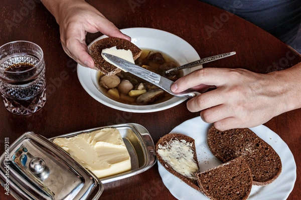 Fototapeta man buttered bread knife. he is left-handed. soup, butter.