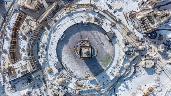 Fototapeta Aerial view of a large circular construction site with snowy surroundings.