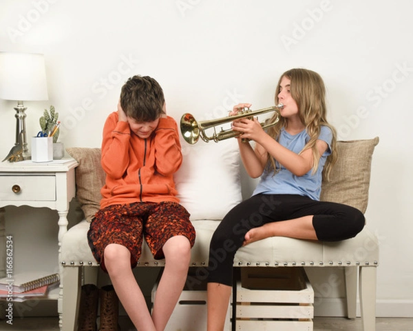 Obraz Girl Student Practing Trumpet Instrument in Front of Brother