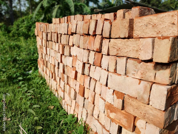 Obraz Stack of Bricks on a Field: A Rustic Touch to Construction and Nature