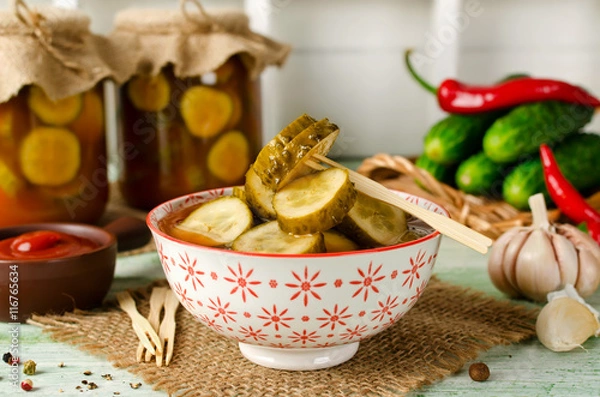 Fototapeta Spicy cucumbers with garlic in tomato marinade