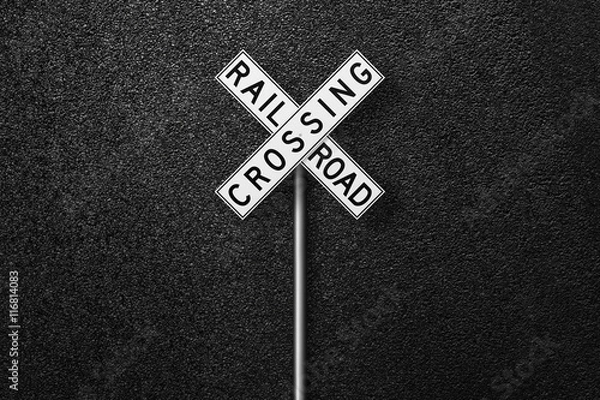 Fototapeta Road sign on a background of asphalt. RAIL ROAD CROSSING. The texture of the tarmac, top view.