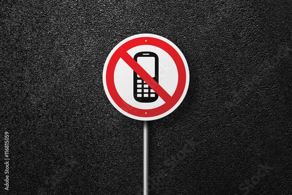 Fototapeta Road sign of the circular shape on a background of asphalt. No phones and sms. The texture of the tarmac, top view.
