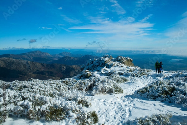 Fototapeta Snowy landscape in the Guadarrama mountain range. Two hikers in the distance