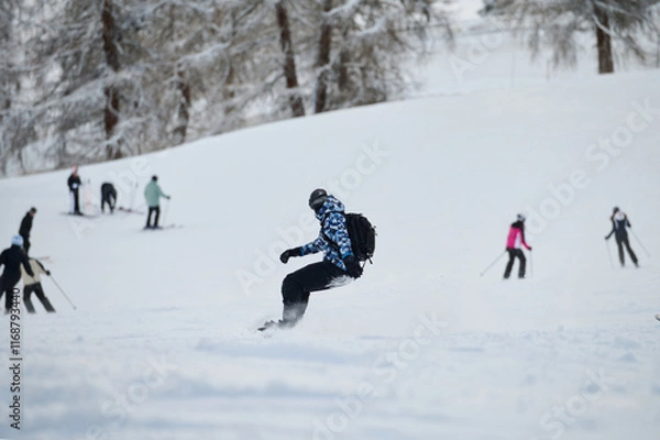 Obraz Snowboarder Gliding Down a Busy Alpine Ski Slope in Winter.