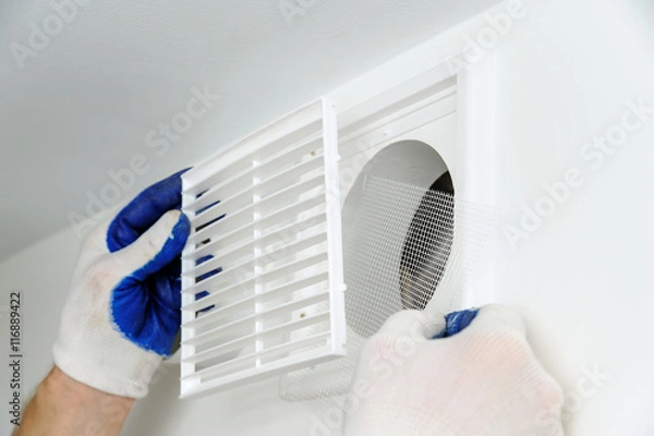 Obraz Worker installs ventilation grille.