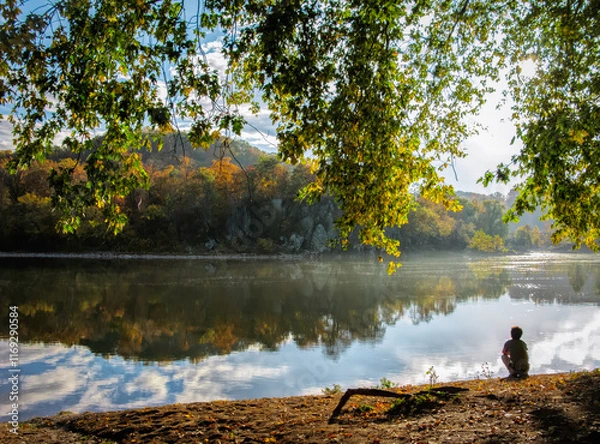 Obraz Man looking at fall reflection on the river