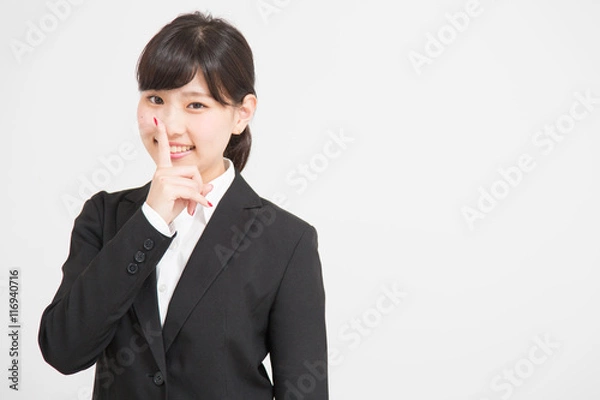 Fototapeta 内緒のポーズをするスーツの女性