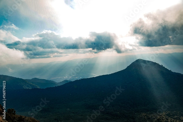 Fototapeta Stunning mountain view with sunlight breaking through clouds nature landscape photography serene environment high angle perspective