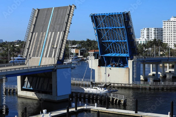 Fototapeta Aerial view of the Las Olas Bridge opening as a sailboat travels on the intracoastal waterways in Fort Lauderdale, Florida, USA. 