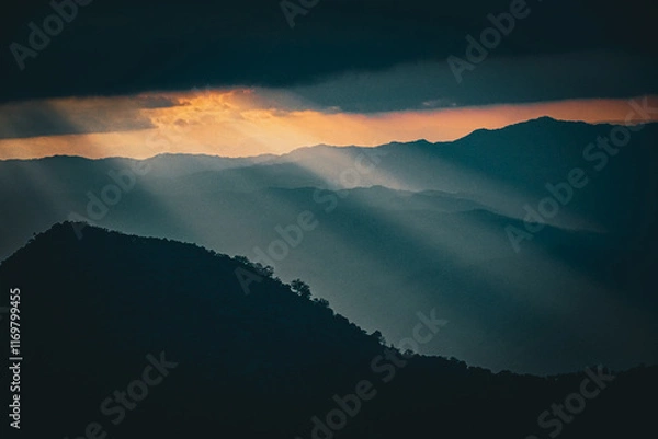 Obraz Dramatic sunlight breaking through clouds mountain range landscape photography natural environment wide angle serenity and reflection