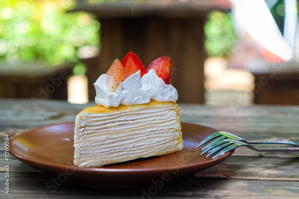 Obraz Piece of crepe cake on plate with strawberries.