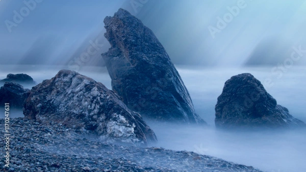 Obraz Water rolling over rocks at coastline mist long exposure scenic background