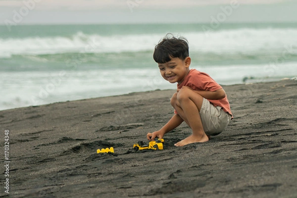 Obraz asian boy playing outside with toy cars at the beach. Child, little boy have fun with toy excavator and dumper in the sand