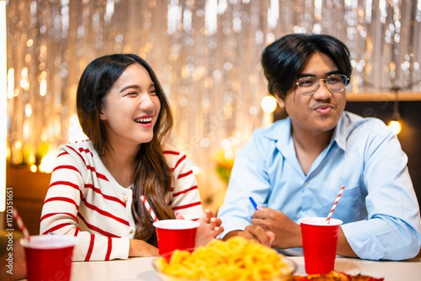 Fototapeta Three friends joyfully celebrating drinking eating drinking and cheerful expressions at house party