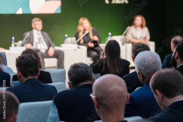 Obraz Corporate panel discussion with a formal audience in attendance making observations and notes. Ideal for concept of business communication and professional interaction.
