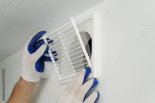 Obraz Worker installs ventilation grille.