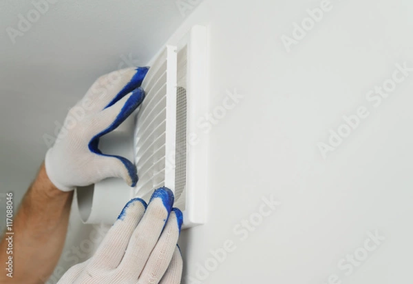 Obraz Worker installs ventilation grille.