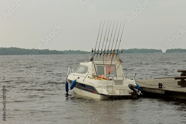 Obraz Fishing boat standing at the pier on a cloudy day