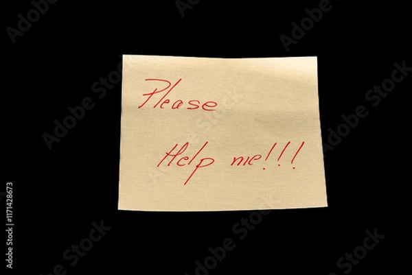 Fototapeta Yellow adhesive paper, similar to a Post-it note, on a black background with the words “Please Help me” and three exclamation marks handwritten in red ink.