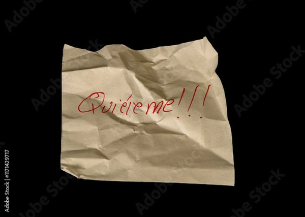 Fototapeta Yellow adhesive paper, similar to a Post-it note, crumpled and then smoothed out, on a black background with the words “Quiereme” Love Me in Spanish handwritten in red ink.