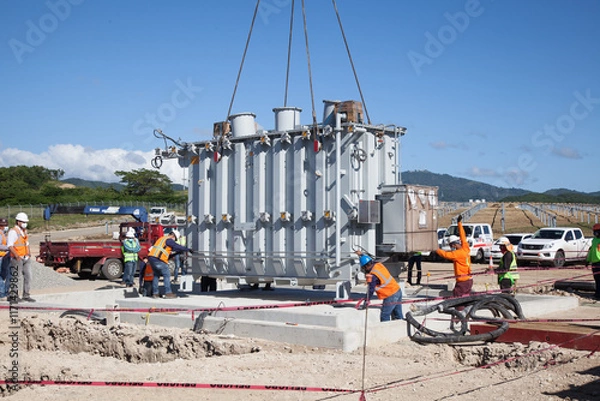 Fototapeta Men's installing a transformer in a solar farm substation 