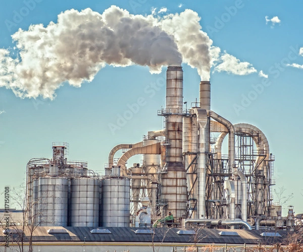Obraz Chimneys and silos of a factory.